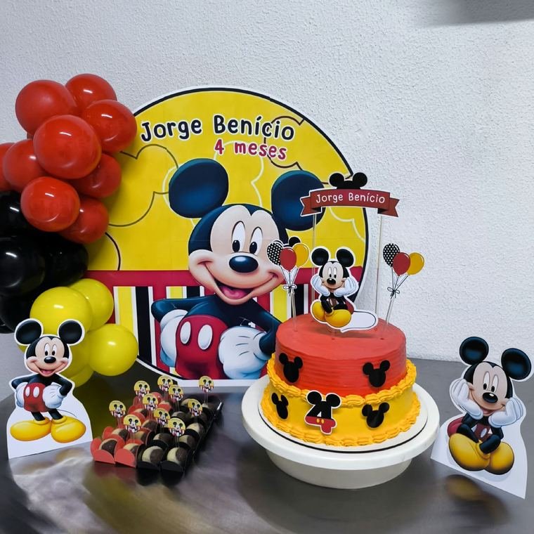 Mesa de aniversário com painel do Mickey, bolo decorado e docinhos personalizados.